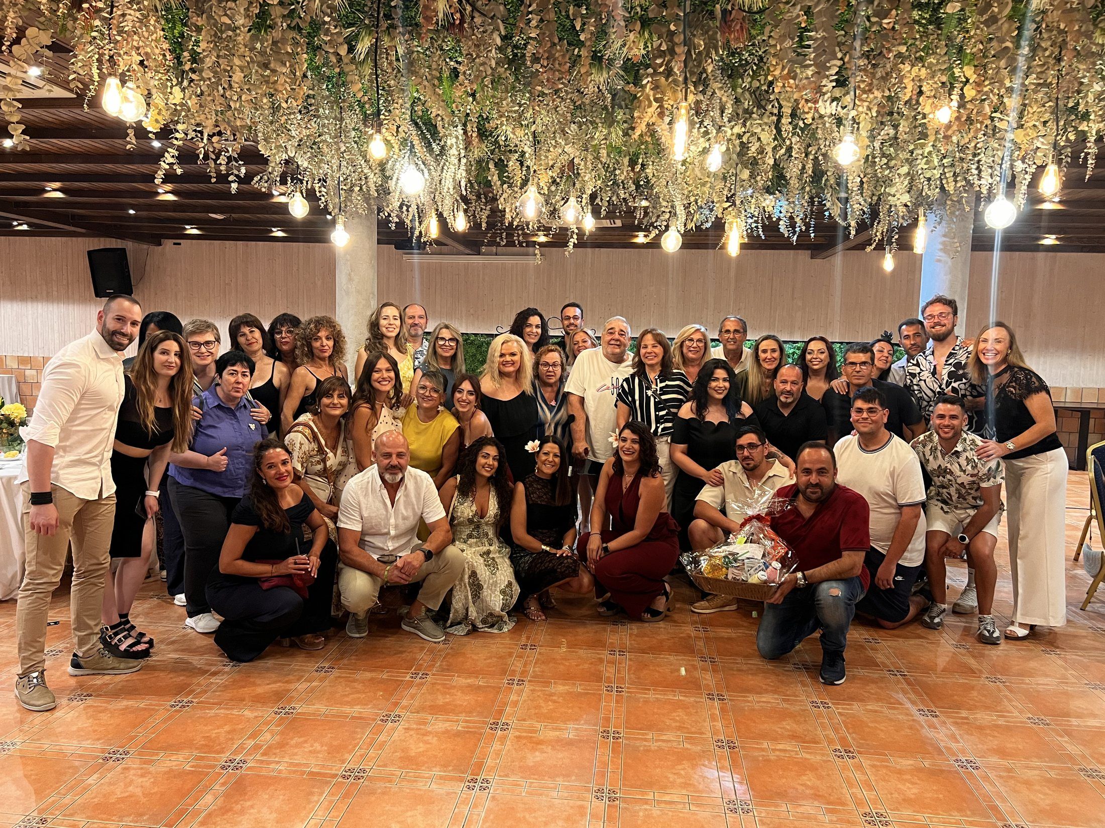 Foto de grupo de la cena bajo las lámparas y las plantas colgantes